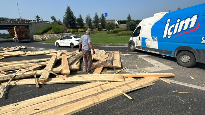 Virajı alamayan tırın dorsesindeki keresteler yola saçıldı