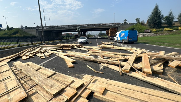 Virajı alamayan tırın dorsesindeki keresteler yola saçıldı